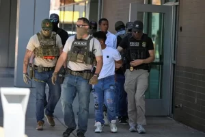 Law enforcement officers take people into custody at an immigration court in Phoenix.